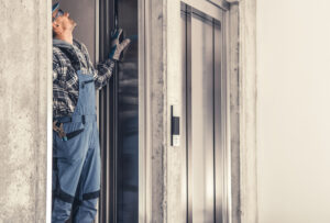 Caucasian Residential Elevator Technician in His 40s Performing Scheduled Maintenance.